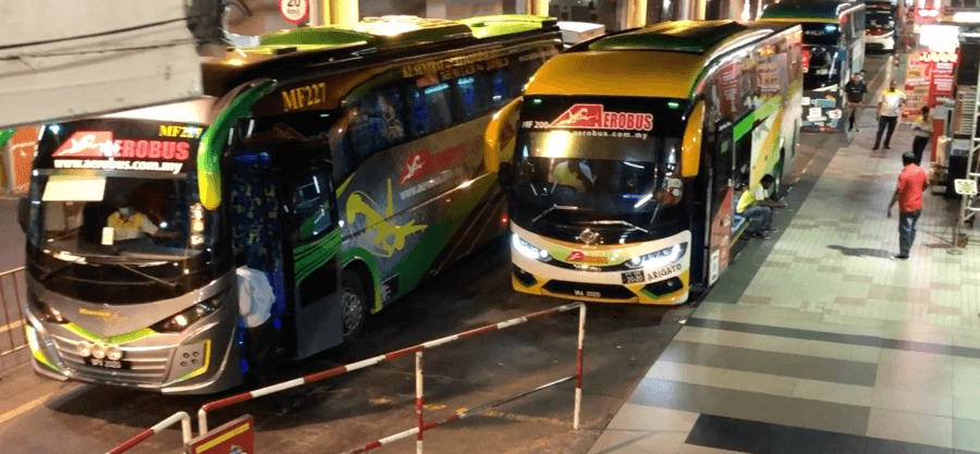 Several of the buses that travel between KL Sentral and KLIA shown parked at the bus station before departure to the airport.