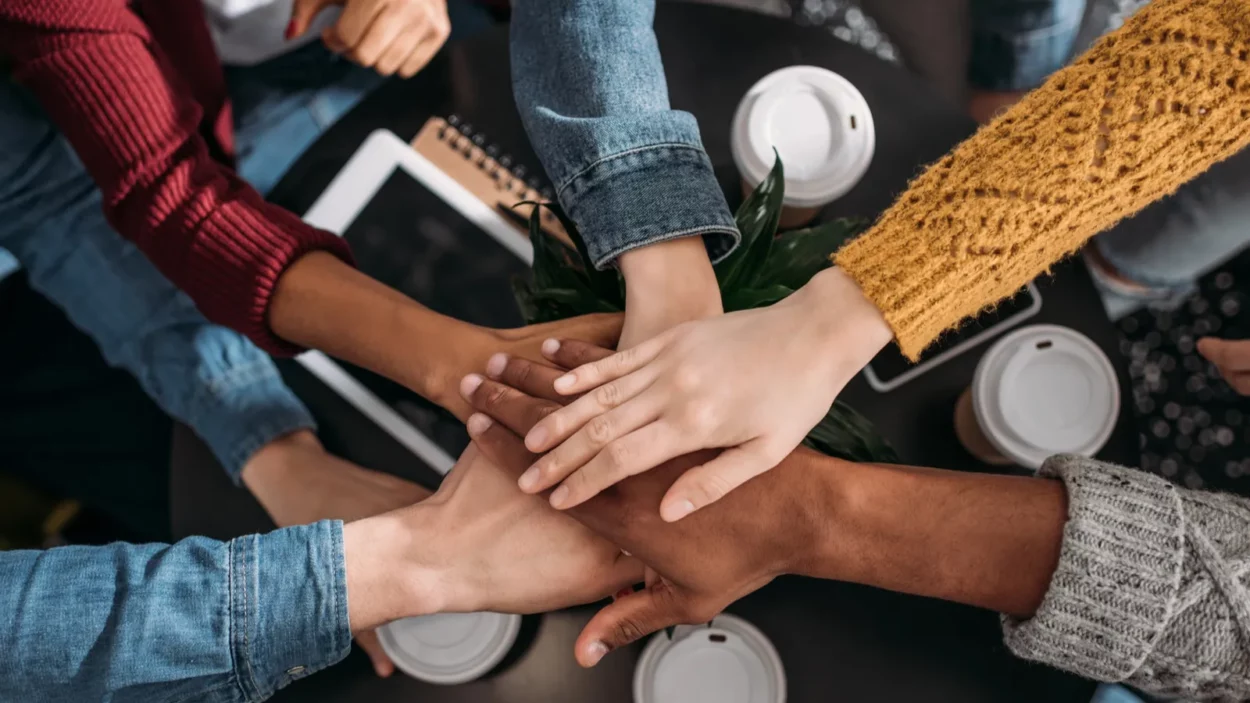 top view of people making team gesture in cafe