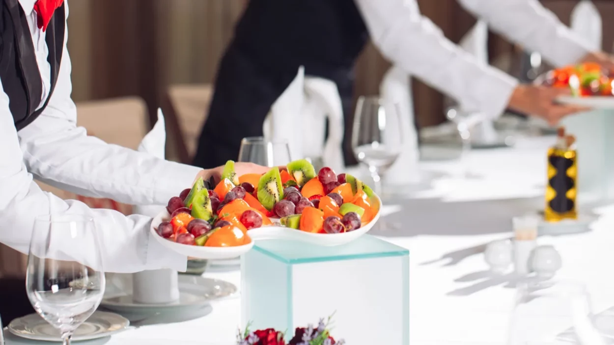 Waiters serving table in the restaurant preparing to receive guests.